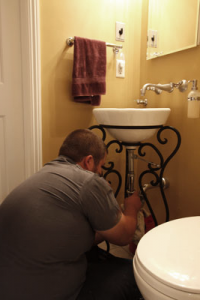 A Service Tech Works On an Ornate Pedastool Sink